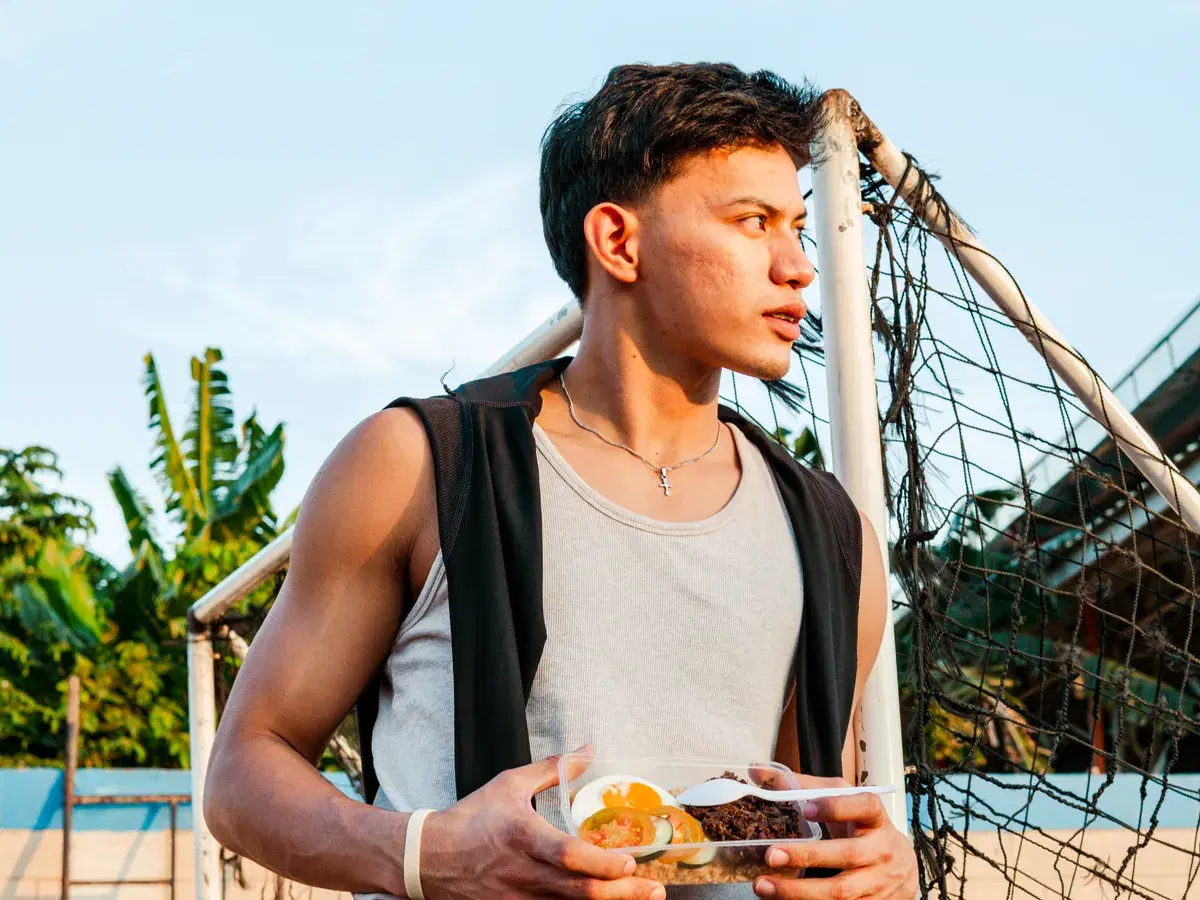 Athlete at the field holding a Chef on a Diet champion meal